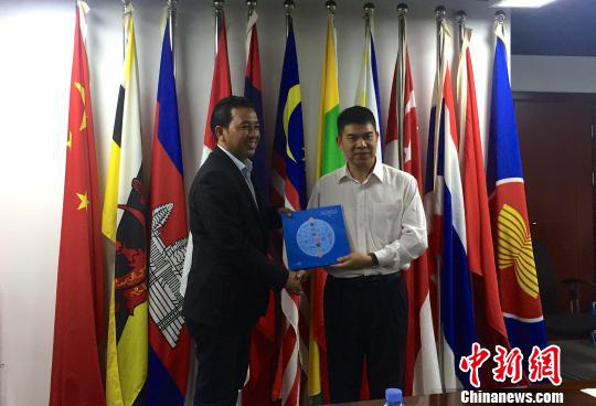 中國—東盟博覽會秘書處副秘書長黃平西（右）與柬埔寨新聞部新聞與傳播總司副總司長春占皮侖（左）互贈禮物。