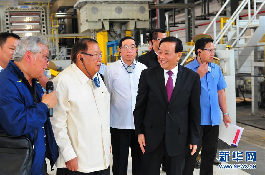 3月10日，在老撾沙灣拿吉省車邦縣，老撾人民革命黨中央總書(shū)記、國(guó)家主席本揚(yáng)（左二）在山東太陽(yáng)紙業(yè)股份有限公司董事長(zhǎng)李洪信（右二）的陪同下視察公司。 新華社記者章建華攝